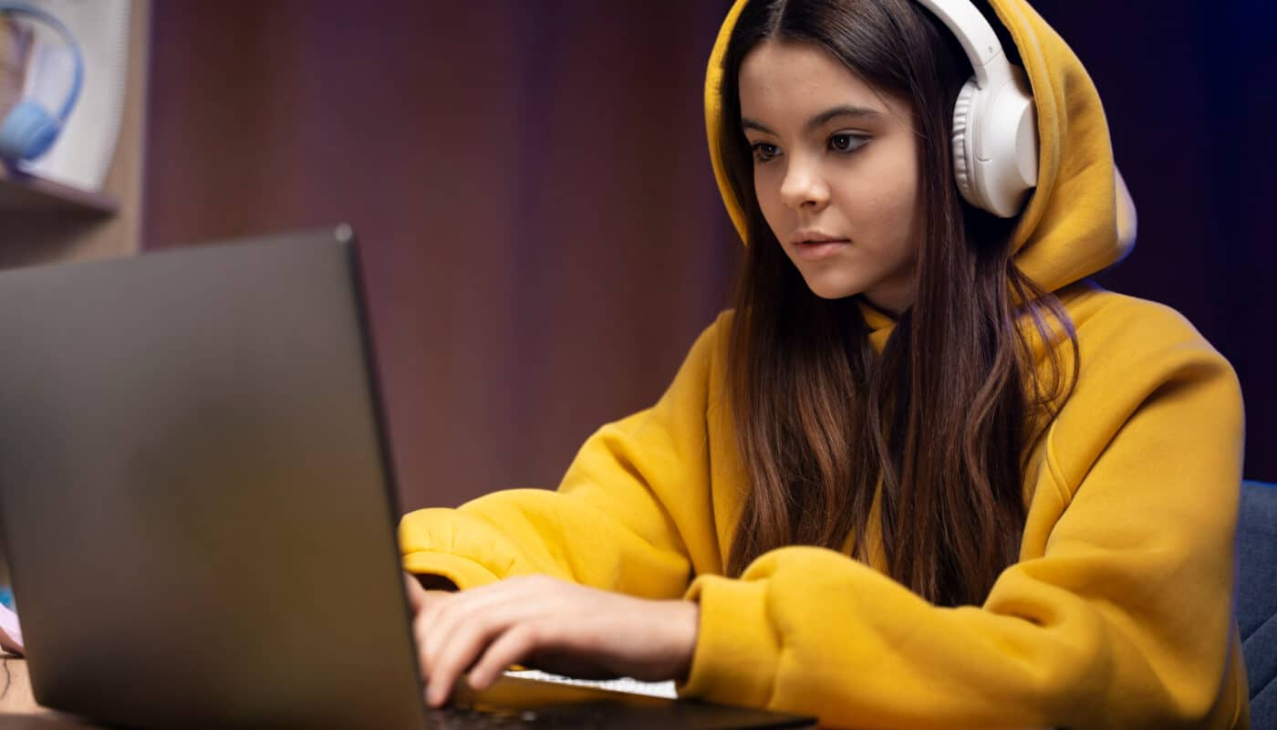 ado avec une capuche et un casque utilise un ordinateur