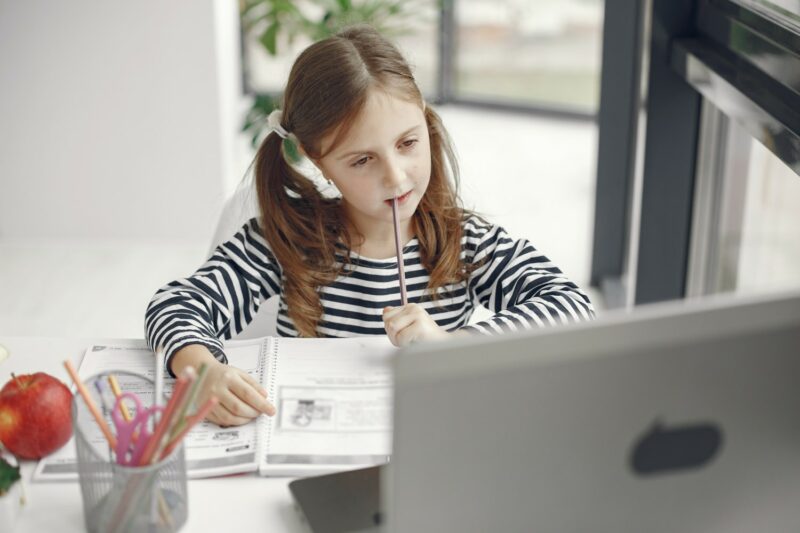 fille utilisant un pc pour ses devoirs