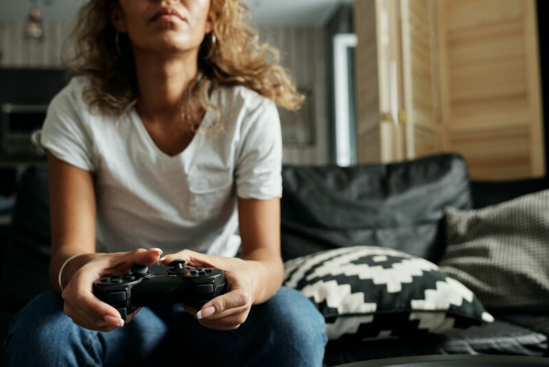 femme joue à la ps4 assise sur un canapé