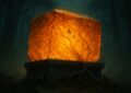 Bloc d'ambre fossilise incandescent pose sur une dalle de pierre dans une foret sombre